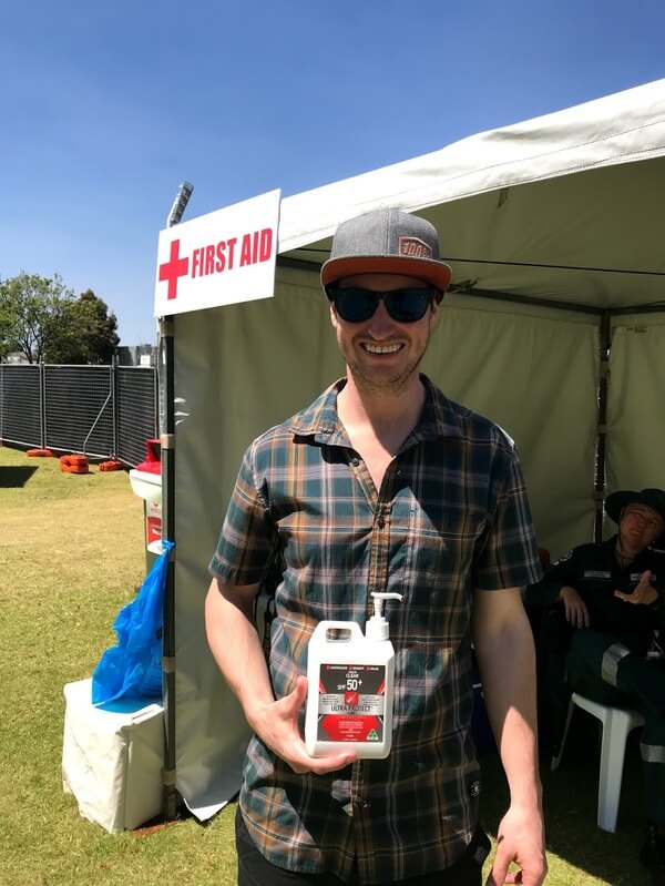 bryce-holding-a-bottle-of-sunscreen-at-the-first-aid-tent