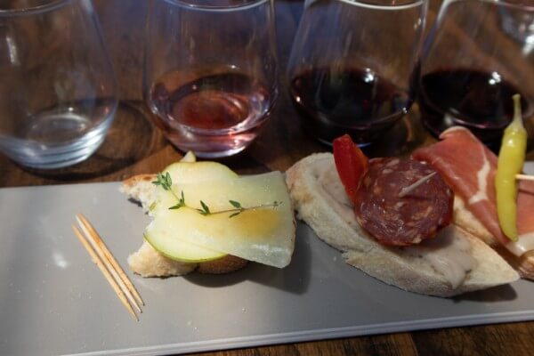 close-up-of-a-rectangle-plate-with-three-pintxos-matched-with-three-wines-on-a-wooden-table-at-pandemonium-wine-estate-swan-valley