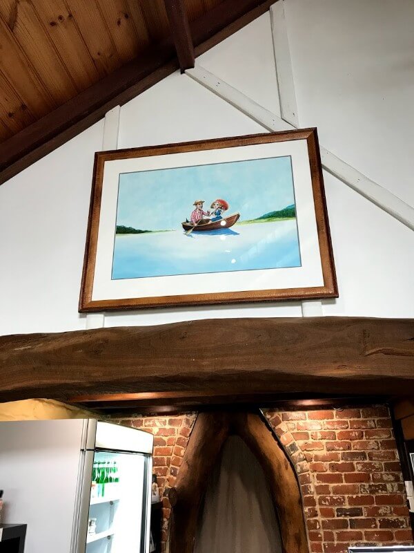 framed-picture-of-the-lake-house-logo-on-the-wall-of-a-man-and-woman-in-a-boat