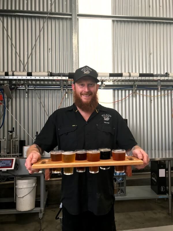 matty-wilson-holding-a-paddle-of-beer-at-wilson-brewing-company