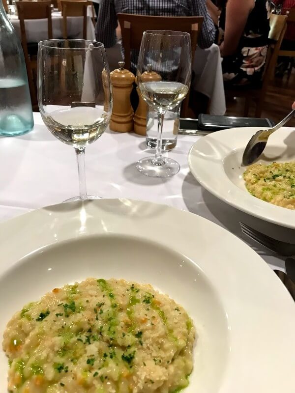 second-course-risotto-con-grano-padano-at-pinelli-estate-winery-restaurant-with-a-glass-of-vermentino-reserve