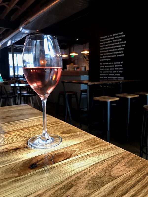 glass of rose wine on table at cake face cellar door