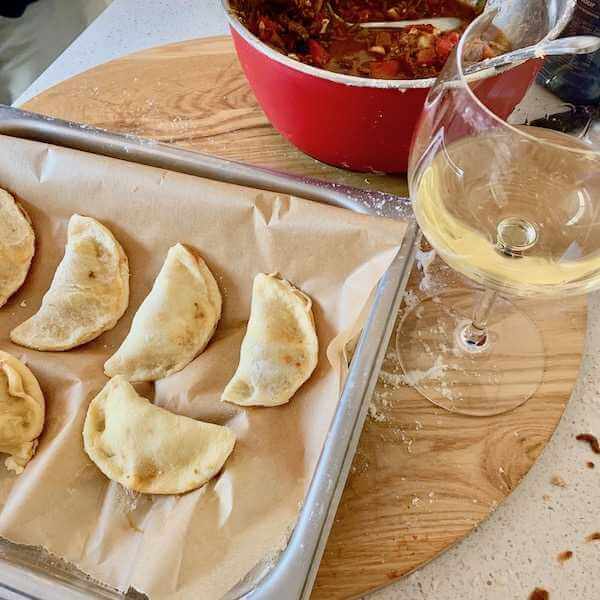 Making empanadas and drinking wine