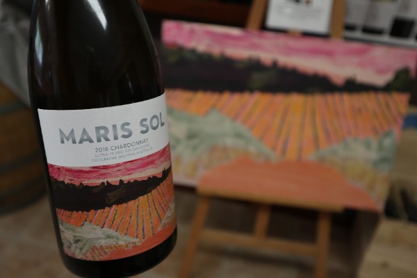 bottle of maris sol chardonnay in front of painting at willow bridge winery