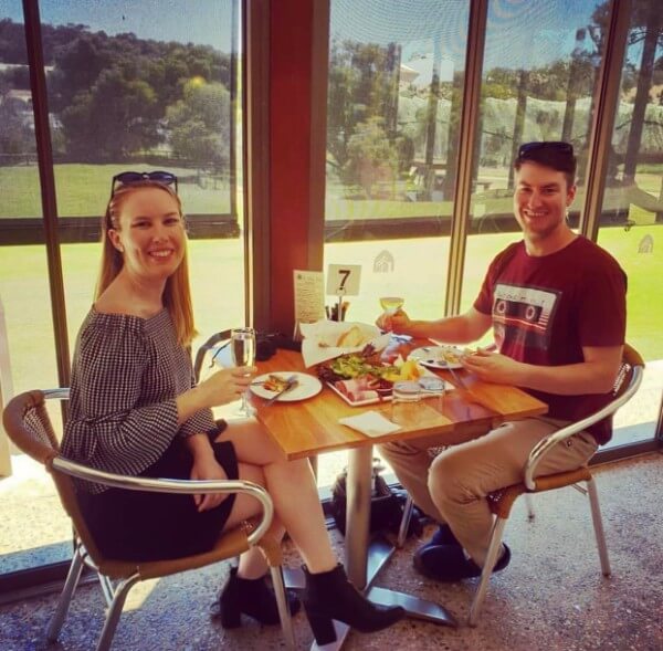 naomi and bryce sitting at a table drinking wine at st aiden winery