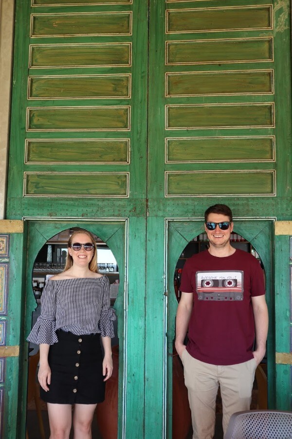 naomi and bryce standing in front of a green double door at green door winery