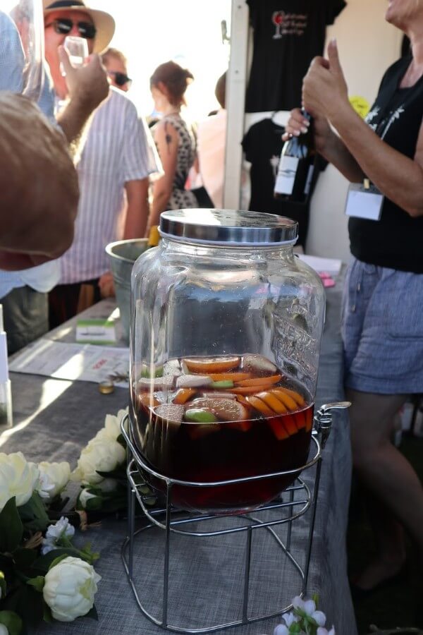 red sangria and fruit in a container on stand