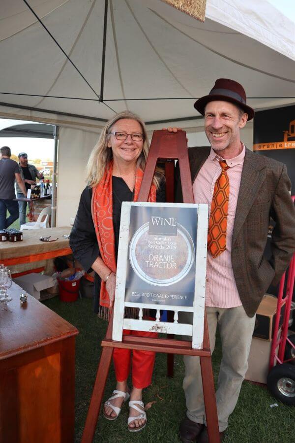 pam and murray standing next to their gourmet traveller wine award for best additional experience at the albany wine and food festival