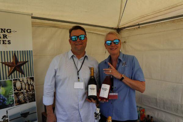 paul and gewn of rising star wines holding a bottle of sparkling wine and brose at the albany wine and food festival