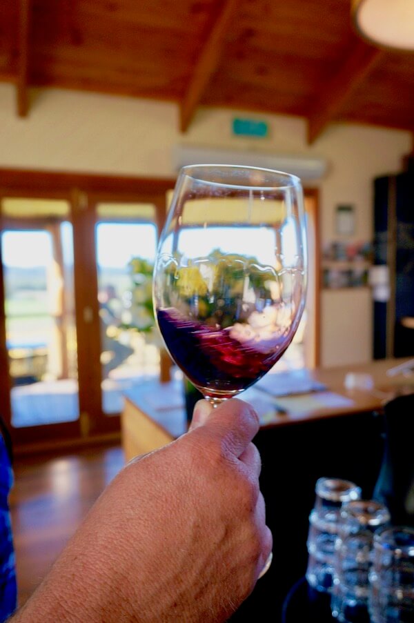 Swirling red wine at Moores Hill Tasmania