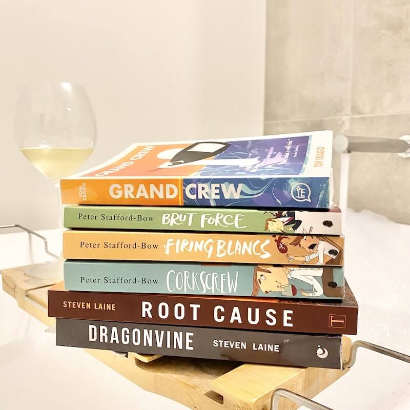 Stack of wine fiction books on bath caddy in bubbles bath